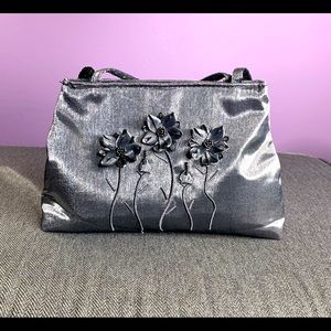 Grey La Rue Satin bag with flower applique.